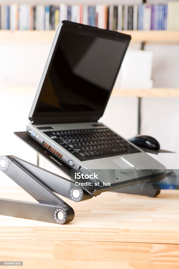 Dyazo silver adjustable aluminum portable laptop stand setup on a wooden office desk.