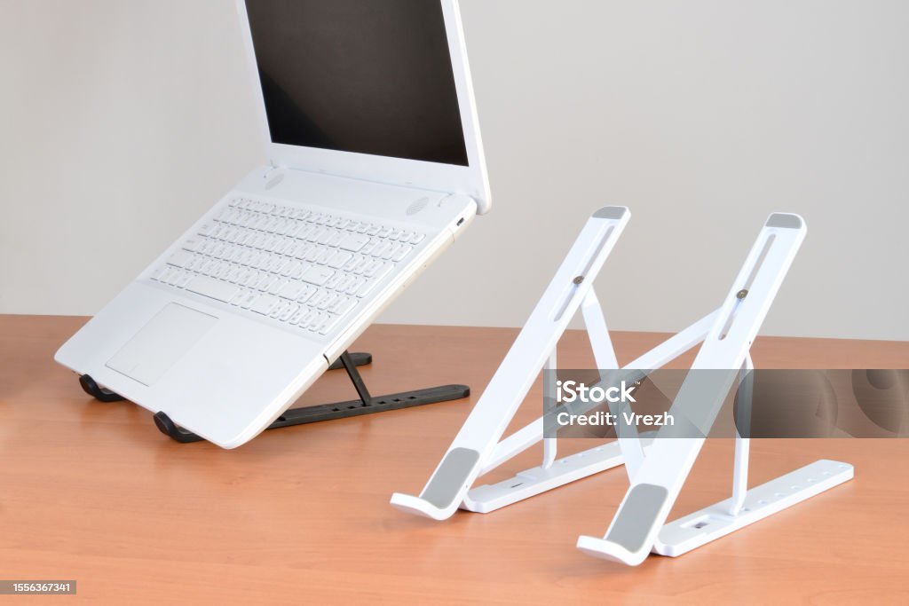 Dyazo silver adjustable aluminum portable laptop stand setup on a wooden office desk.
